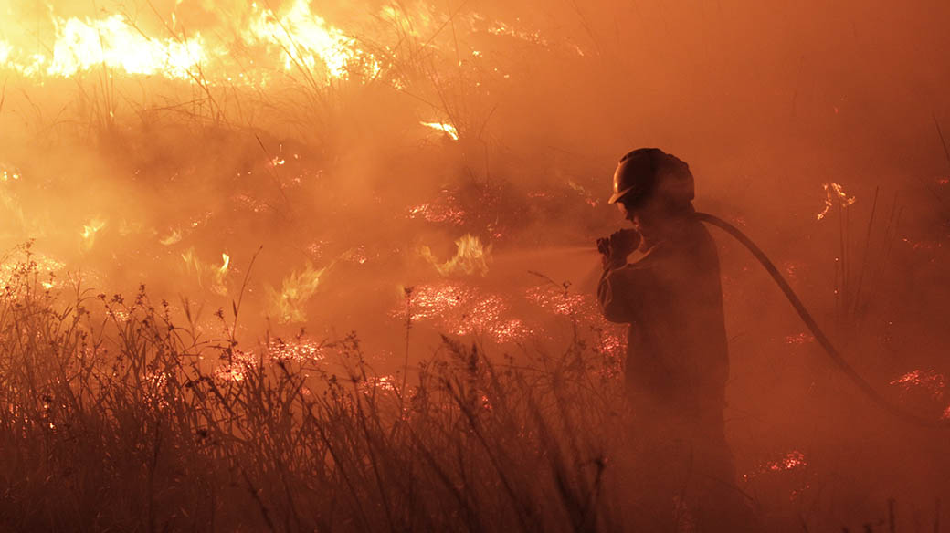 Un bombero voluntario de San Miguel intenta apagar el fuego